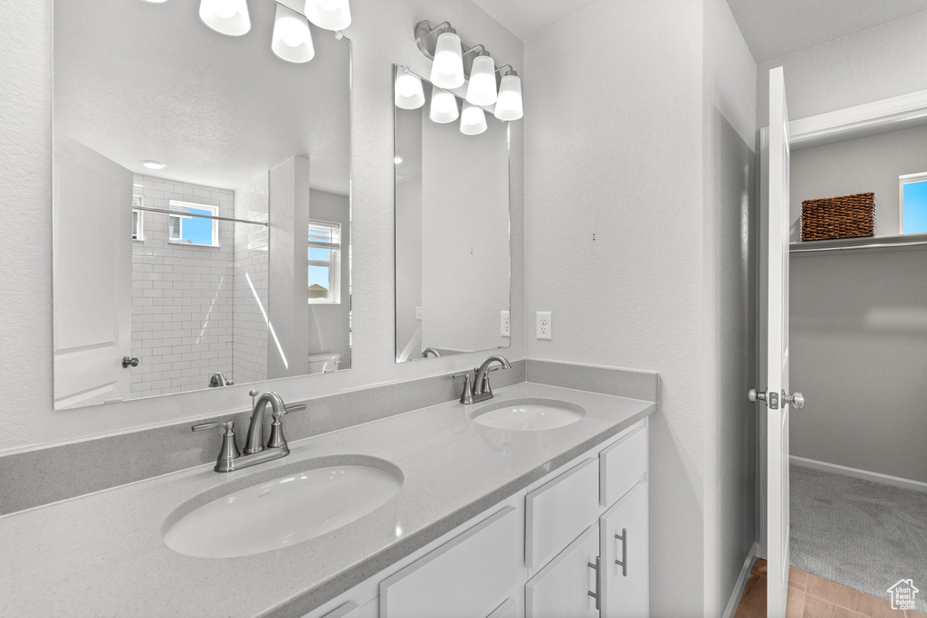 Bathroom featuring a textured ceiling, vanity, and walk in shower