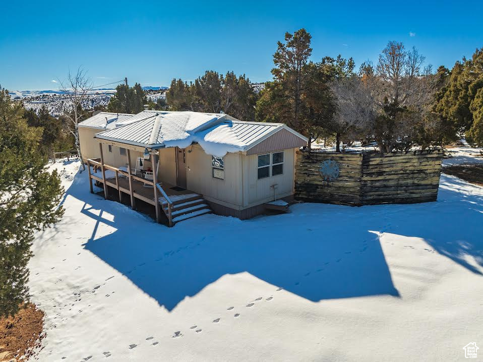 Snow covered property featuring a wooden deck