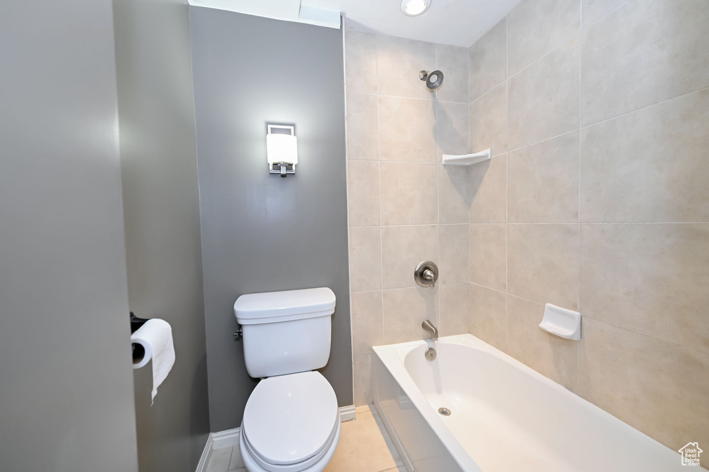 Full bath featuring toilet, bathing tub / shower combination, and baseboards