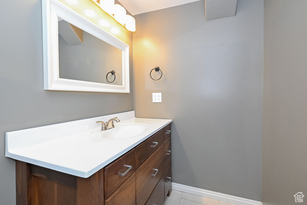 Bathroom featuring vanity, baseboards, and tile patterned flooring