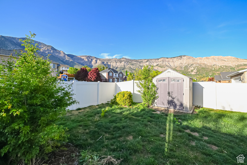 View of yard featuring a mountain view, a shed, and an outdoor structure