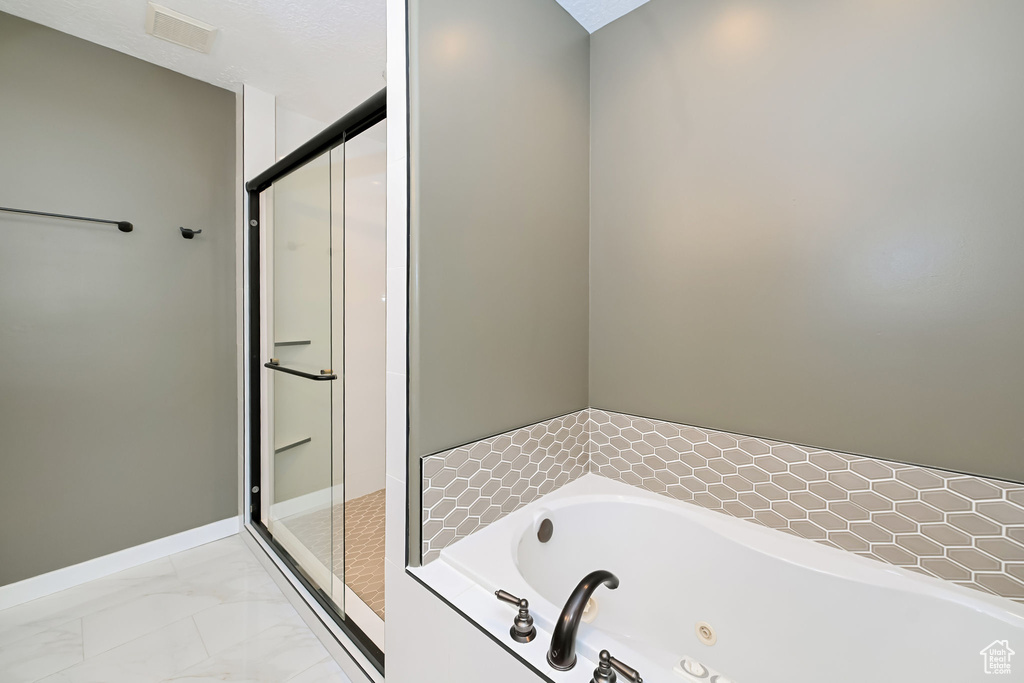 Full bath with a whirlpool tub, a stall shower, marble finish floors, and baseboards
