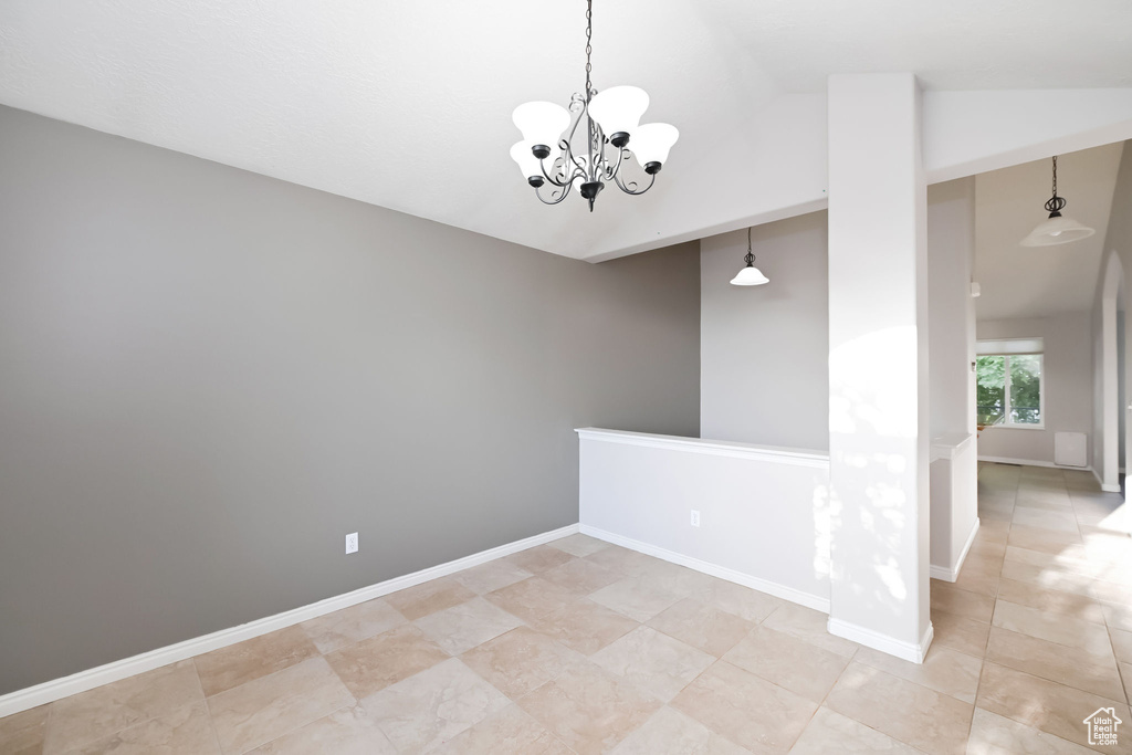 Unfurnished room with a chandelier, lofted ceiling, light tile patterned flooring, and baseboards