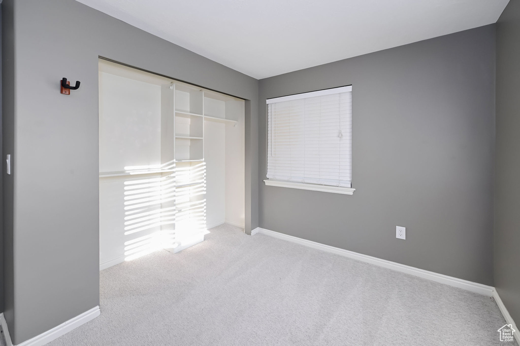 Unfurnished bedroom with carpet flooring, baseboards, and a closet