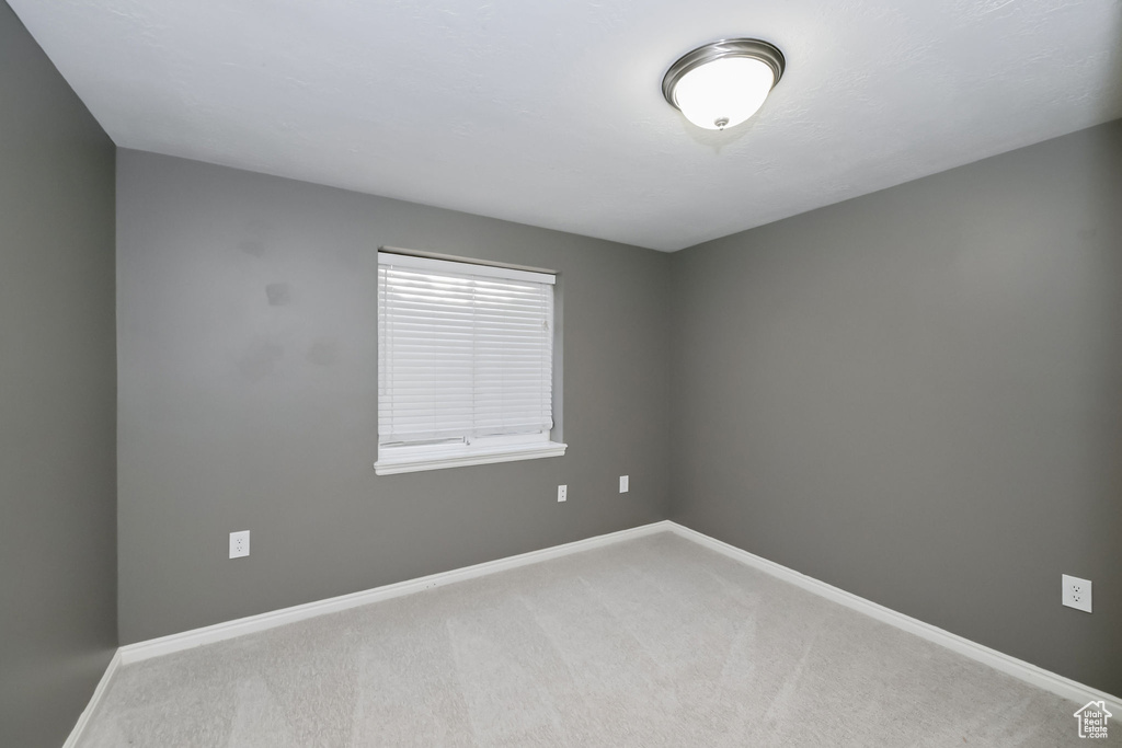 Empty room featuring carpet and baseboards