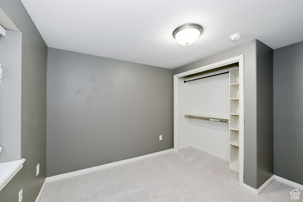 Unfurnished bedroom featuring carpet flooring, baseboards, and a closet