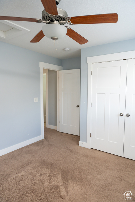 Unfurnished bedroom with light colored carpet, a closet, and ceiling fan
