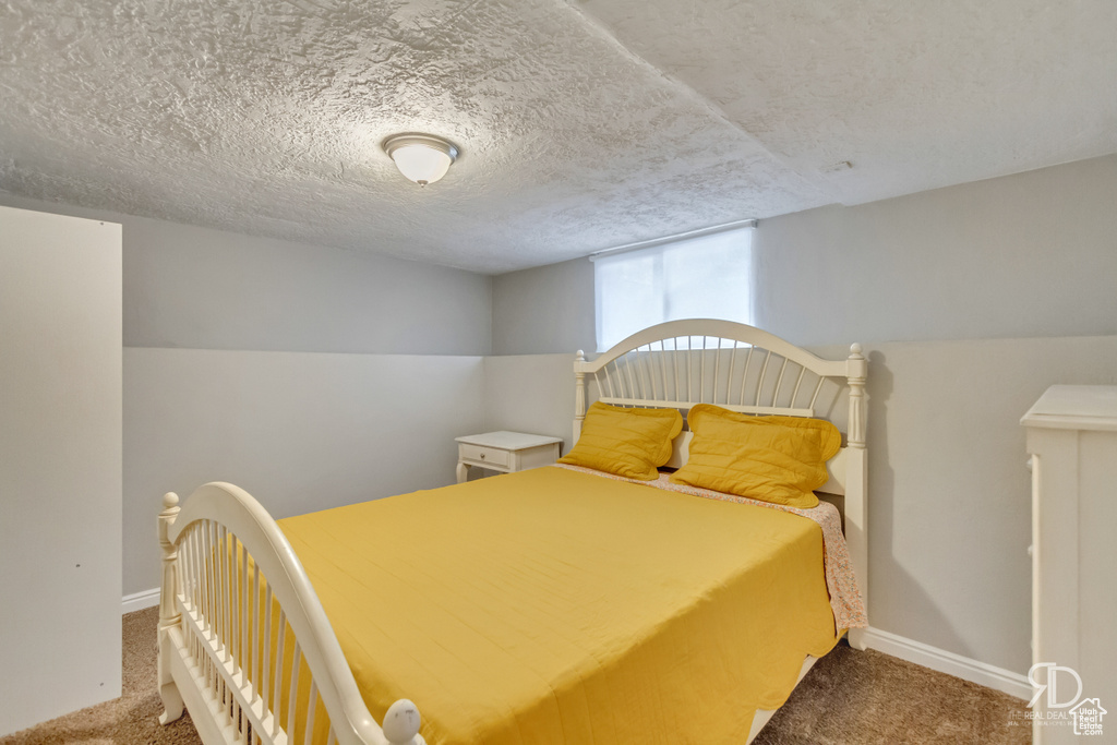 Bedroom featuring carpet flooring, lofted ceiling, and a textured ceiling