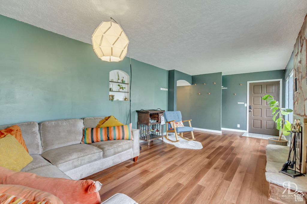 Living room featuring wood-type flooring and a textured ceiling