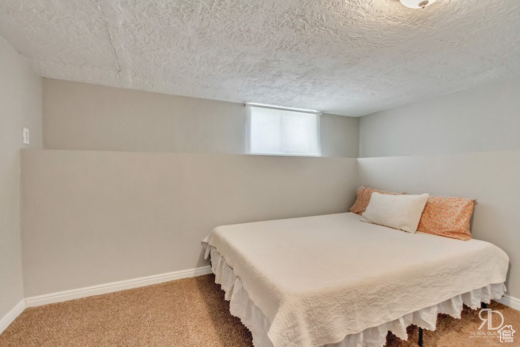 Bedroom featuring carpet flooring and a textured ceiling