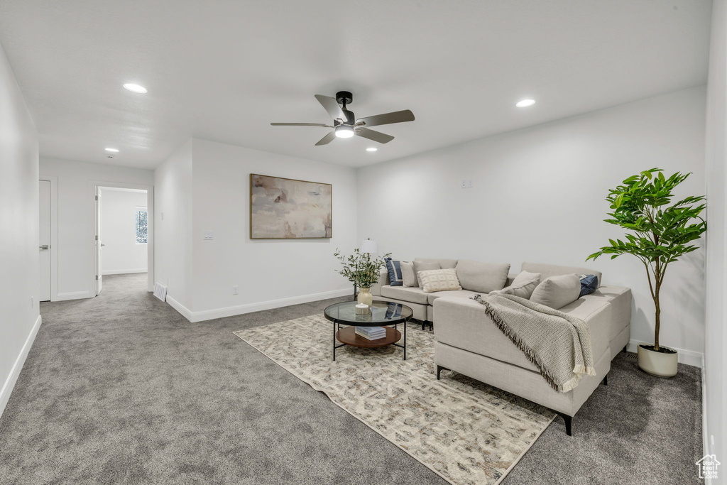 Carpeted living area with baseboards, ceiling fan, and recessed lighting