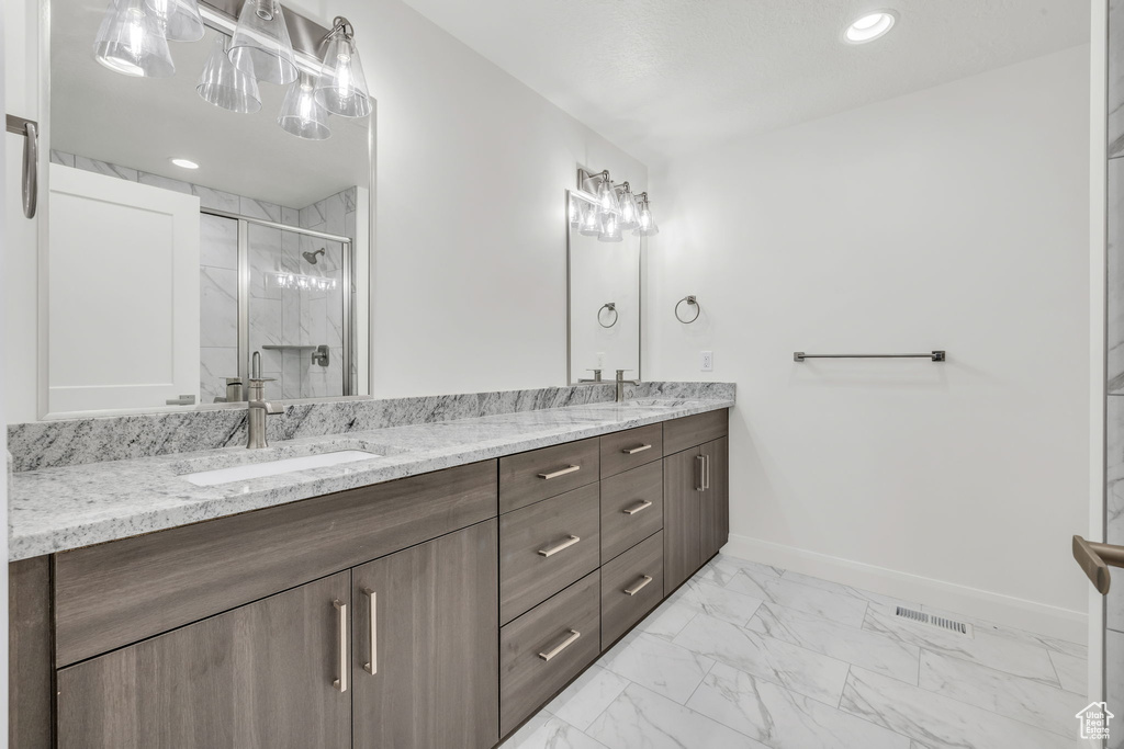 Bathroom with a sink, visible vents, baseboards, marble finish floor, and a marble finish shower