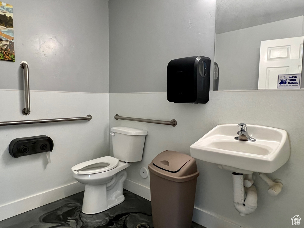 Bathroom featuring concrete floors and toilet