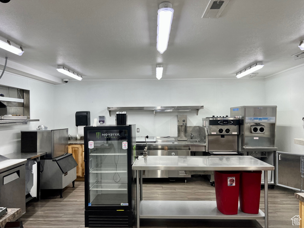 Kitchen featuring a textured ceiling, stainless steel counters, and dark wood-type flooring