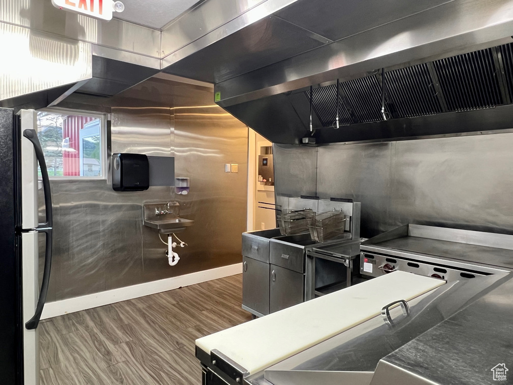 Kitchen with dark hardwood / wood-style floors, refrigerator, and extractor fan