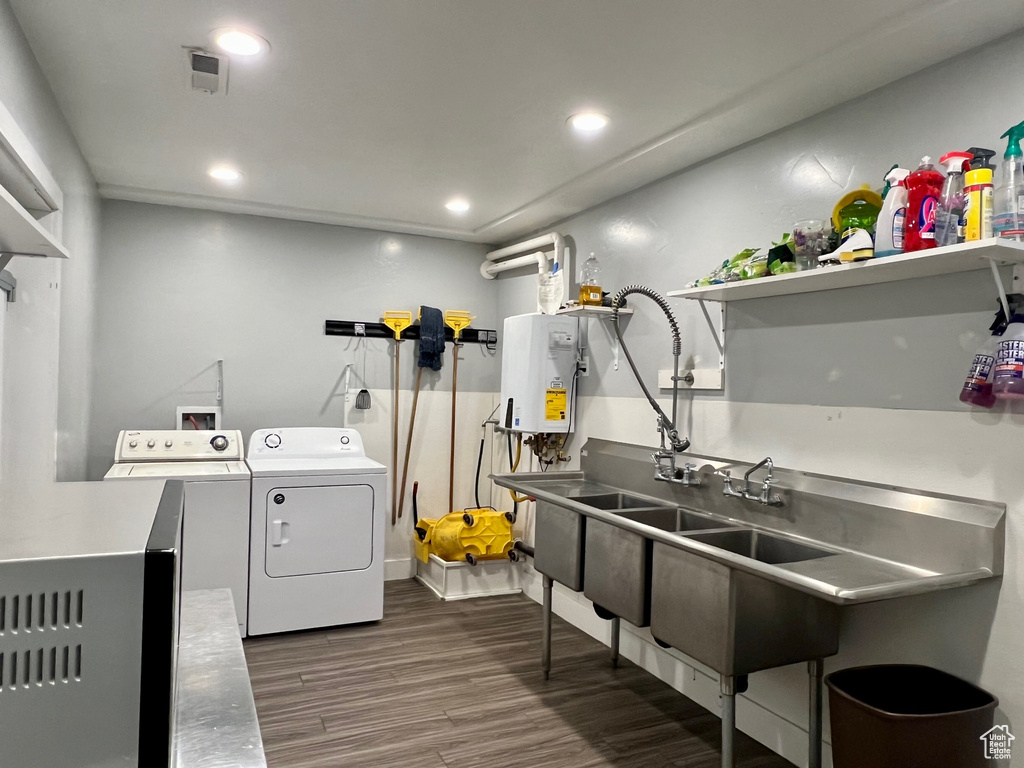 Washroom featuring independent washer and dryer, tankless water heater, and dark wood-type flooring