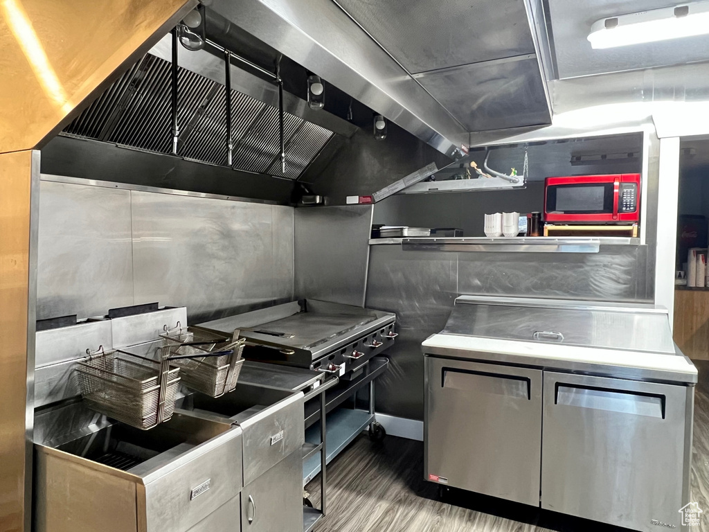 Kitchen featuring hardwood / wood-style floors, wall chimney exhaust hood, and high end range oven