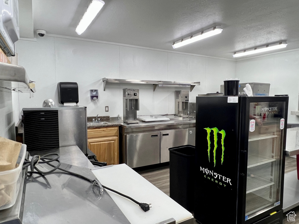 Kitchen with black refrigerator, a textured ceiling, refrigerator, and sink