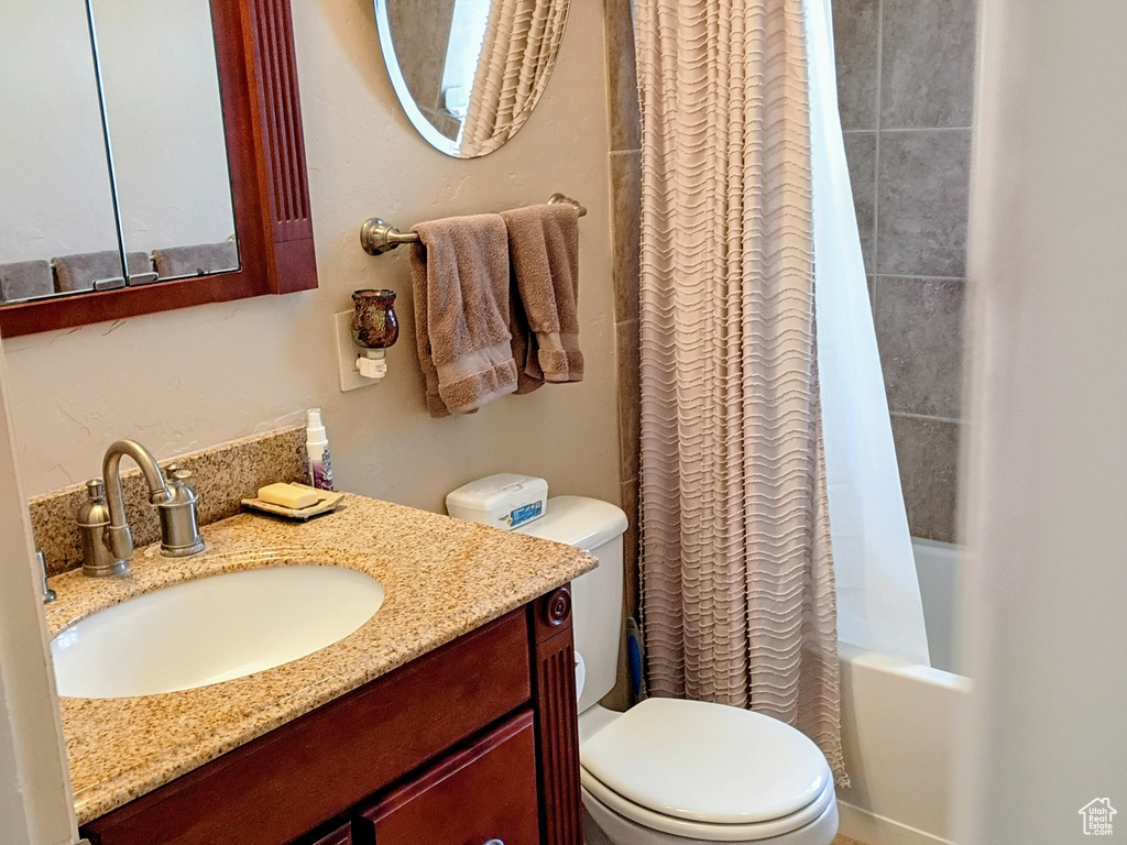 Full bathroom featuring toilet, tile patterned flooring, shower / bathtub combination with curtain, and vanity