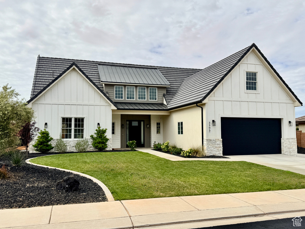 Modern inspired farmhouse with concrete driveway, board and batten siding, a front lawn, and metal roof