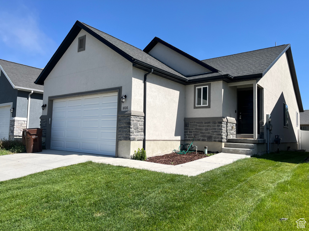 Ranch-style house with stone siding, a garage, driveway, stucco siding, and a front lawn