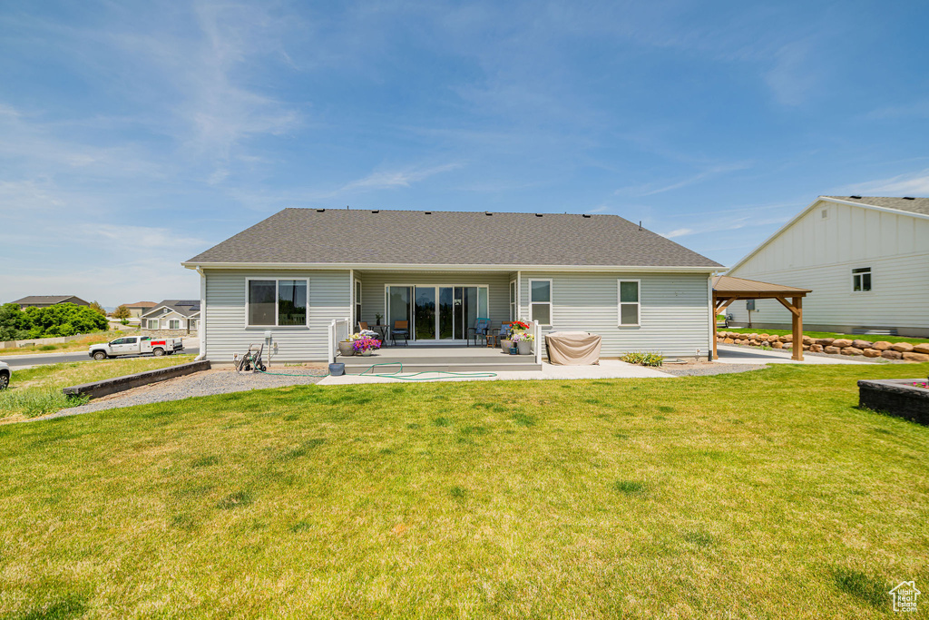 Back of house featuring a patio area, a gazebo, a lawn, and a shingled roof