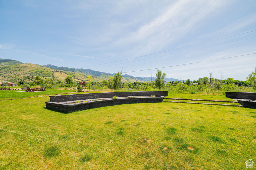 View of grassy yard with a mountain view and a view of countryside