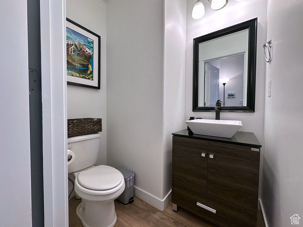 Bathroom featuring hardwood / wood-style floors, vanity, and toilet