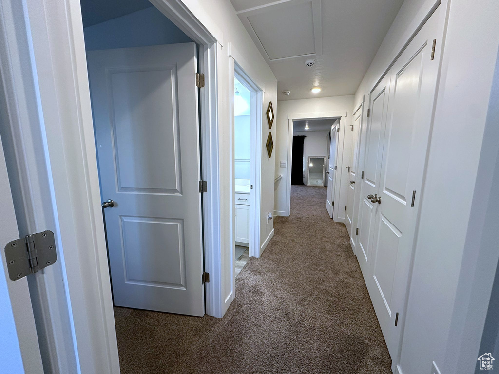 Hallway featuring dark carpet