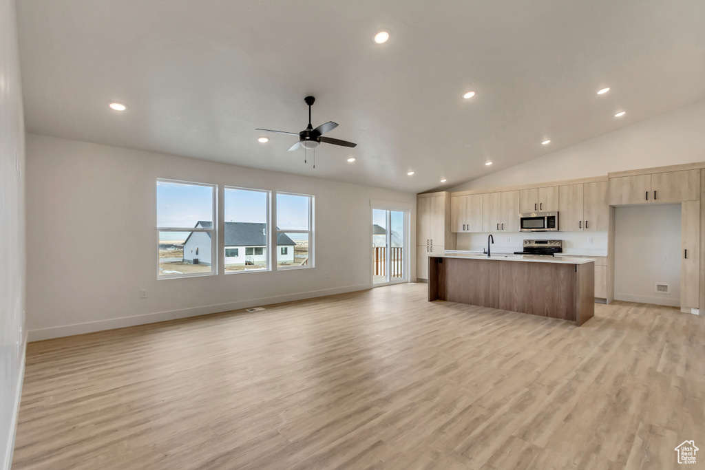 Kitchen with ceiling fan, sink, a kitchen island with sink, appliances with stainless steel finishes, and light wood-type flooring