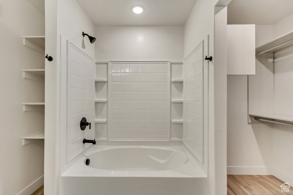 Bathroom with shower / bathing tub combination and hardwood / wood-style floors