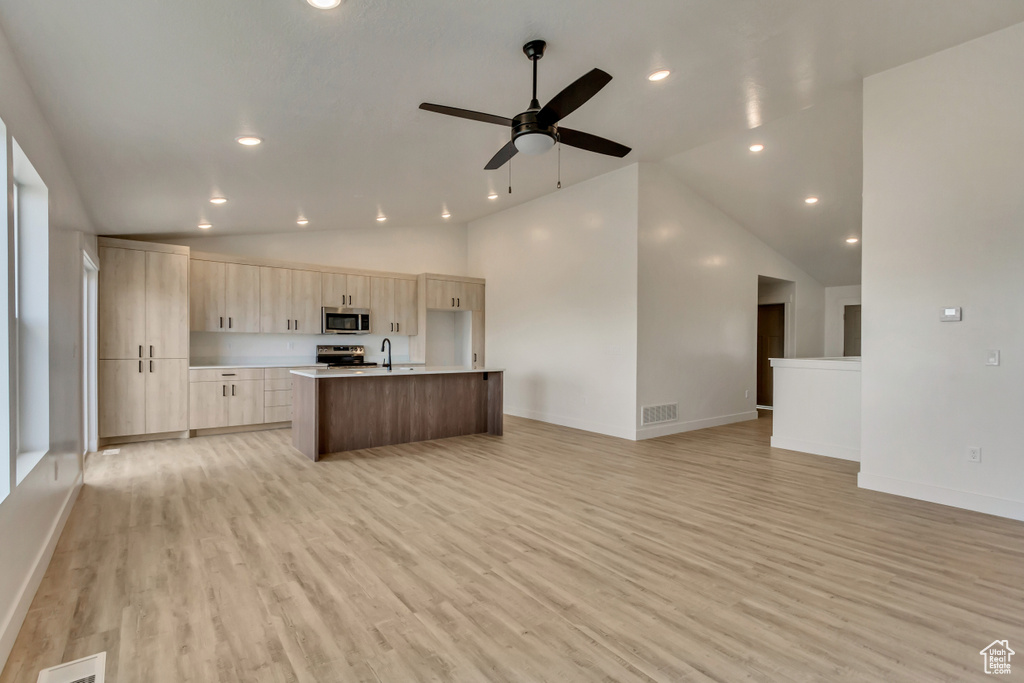 Kitchen featuring a kitchen island with sink, sink, light hardwood / wood-style flooring, ceiling fan, and appliances with stainless steel finishes