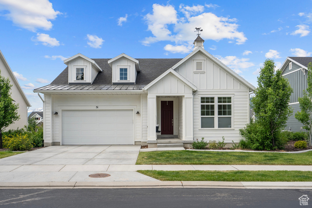 View of front of home featuring a garage, board and batten siding, and driveway