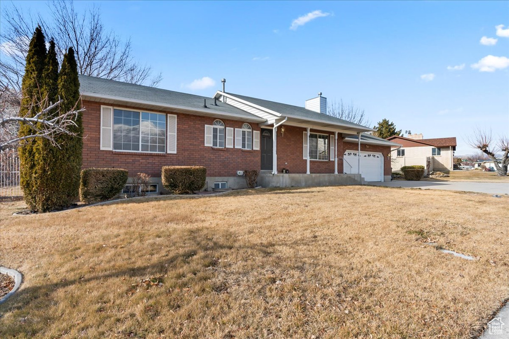 Ranch-style home with a garage and a front lawn