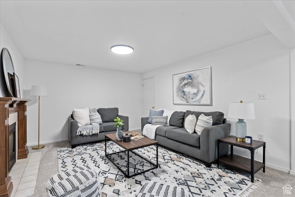 Carpeted living room featuring a tiled fireplace