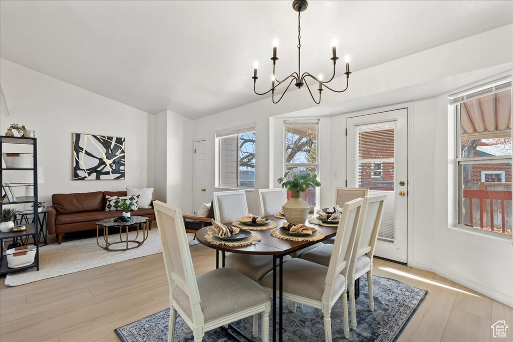 Dining area with an inviting chandelier and light hardwood / wood-style flooring