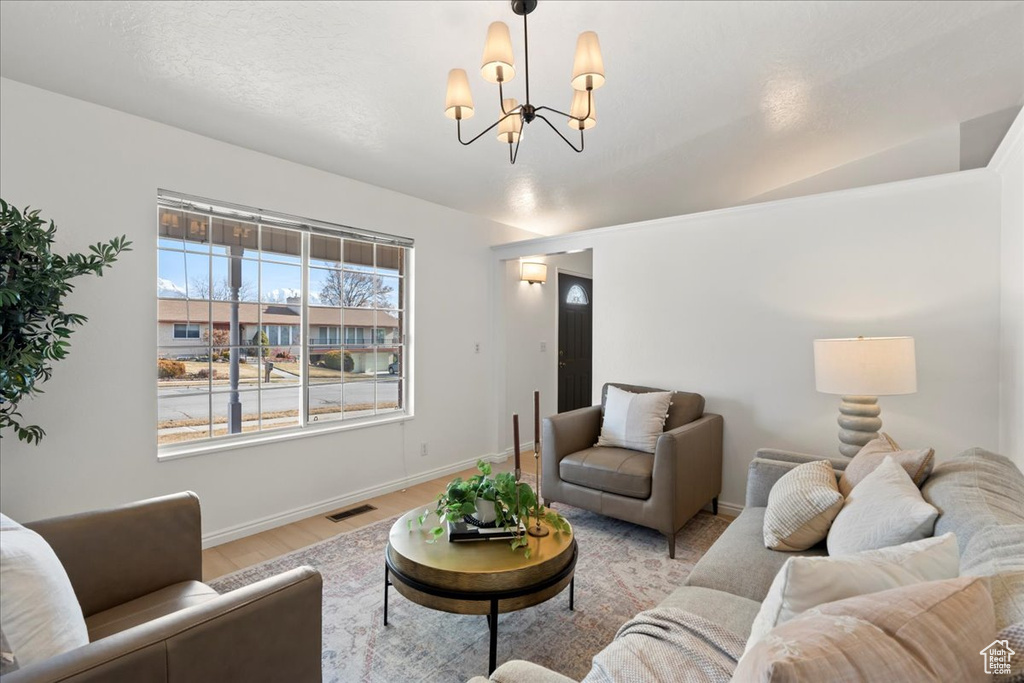 Living room with a chandelier and light hardwood / wood-style floors