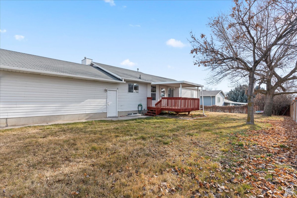 Back of house featuring a deck and a yard