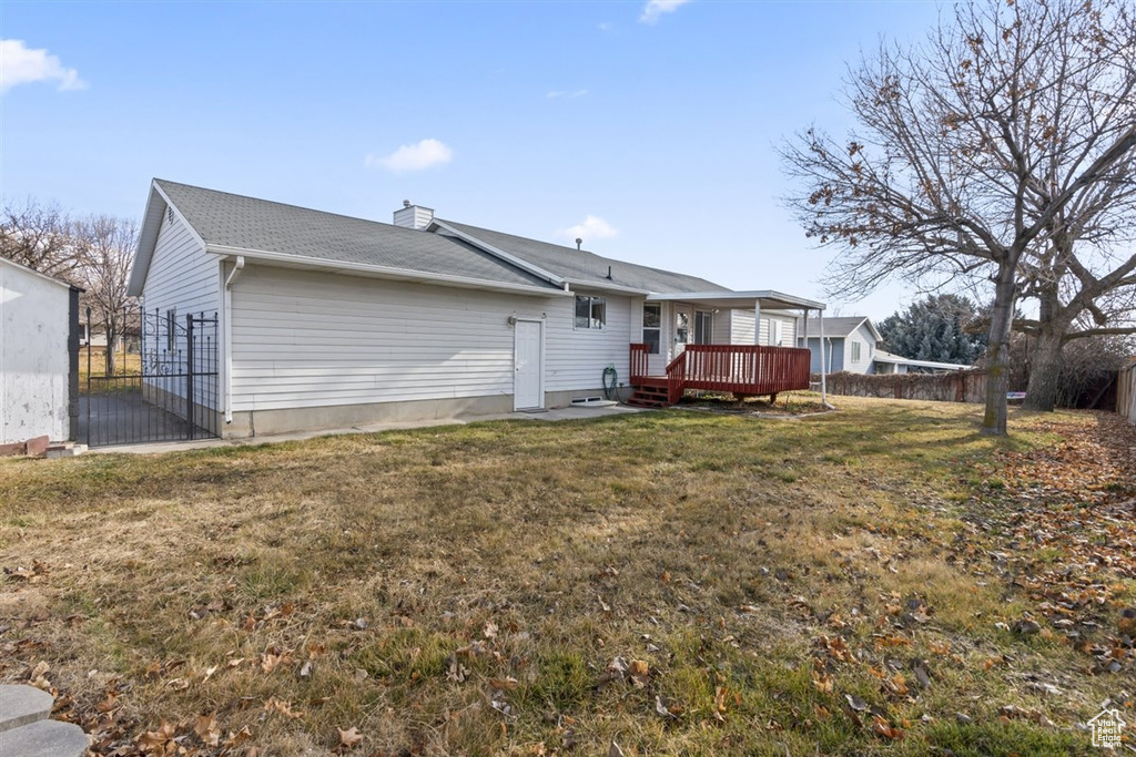 Back of property with a yard and a deck