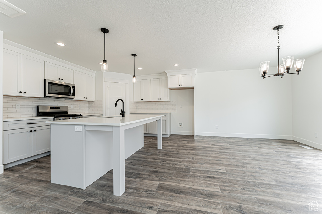 Kitchen featuring stainless steel appliances, a sink, recessed lighting, backsplash, and a chandelier