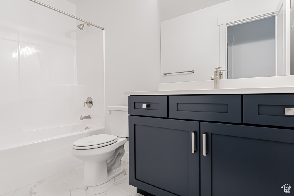 Bathroom with marble finish floor, vanity, toilet, and shower / bathing tub combination
