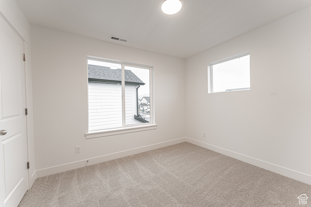 Spare room with visible vents, carpet floors, and baseboards