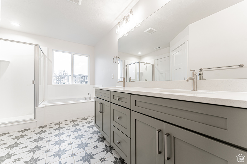 Full bathroom with visible vents, double vanity, a stall shower, a sink, and tile patterned floors