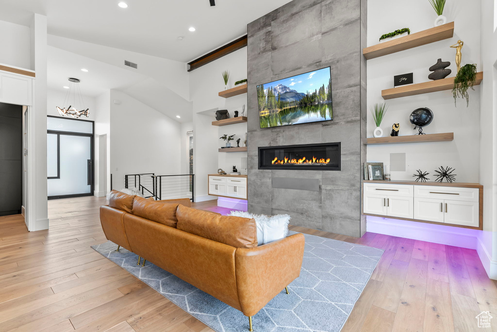 Living room with a fireplace and light hardwood / wood-style flooring