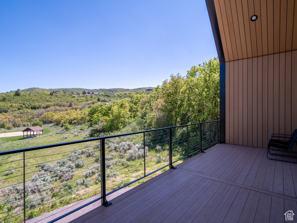 Wooden terrace featuring a wooded view