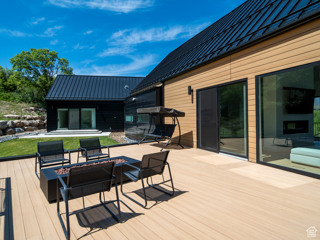 Wooden terrace featuring a fire pit