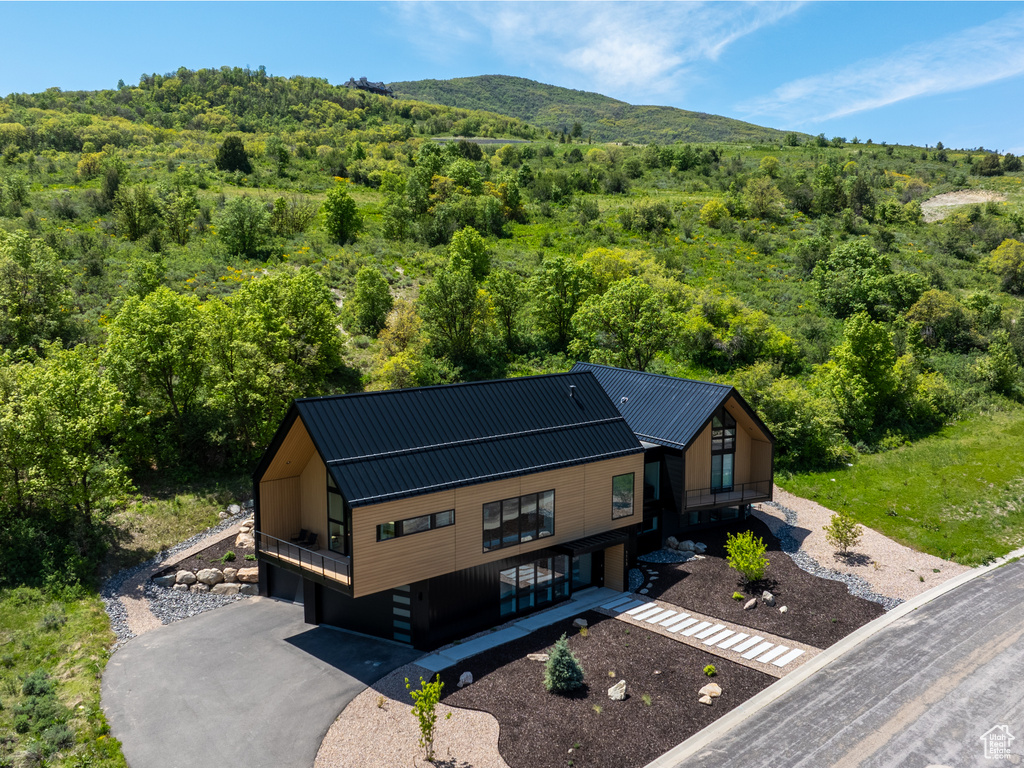 Aerial view of property and surrounding area featuring a forest