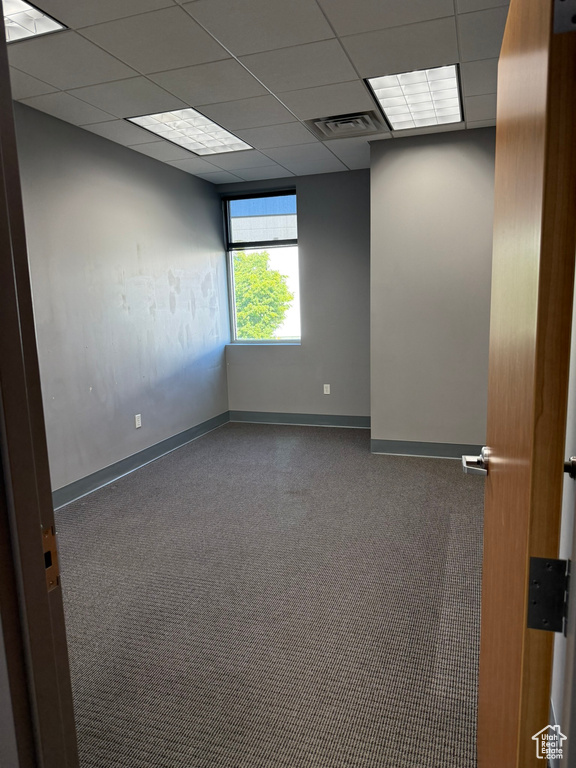 Unfurnished room with baseboards, a drop ceiling, carpet floors, and visible vents