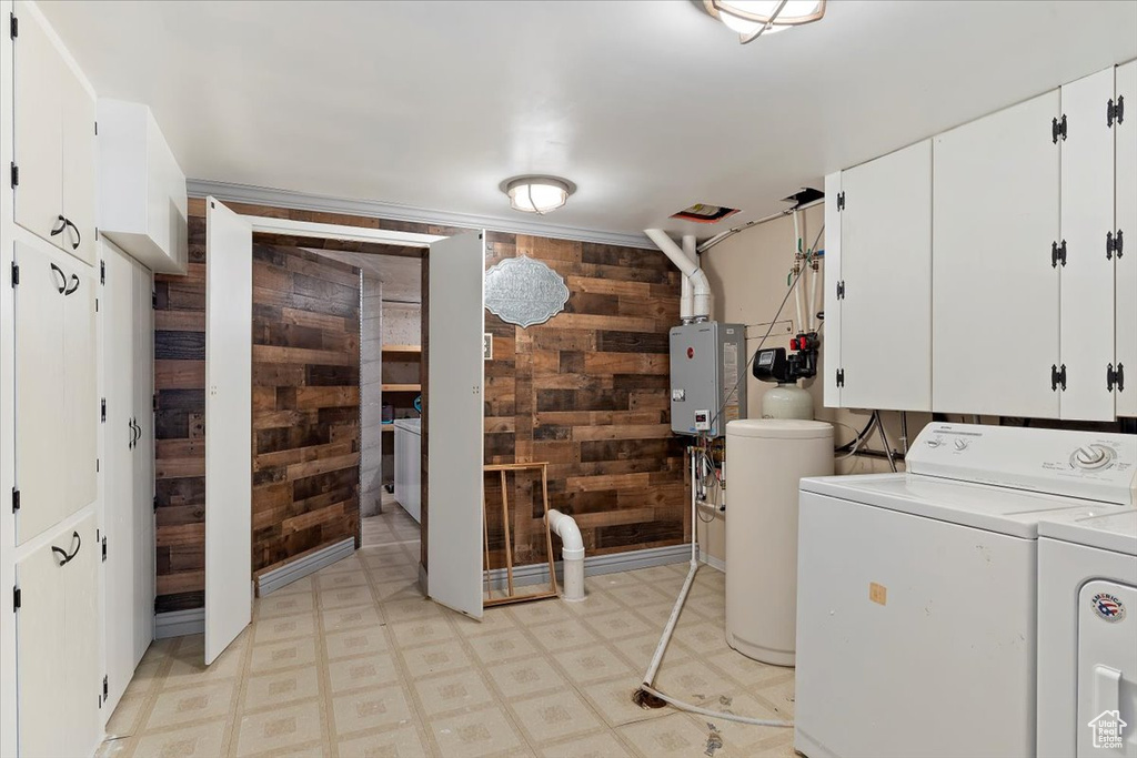 Laundry room with cabinets, independent washer and dryer, and wooden walls