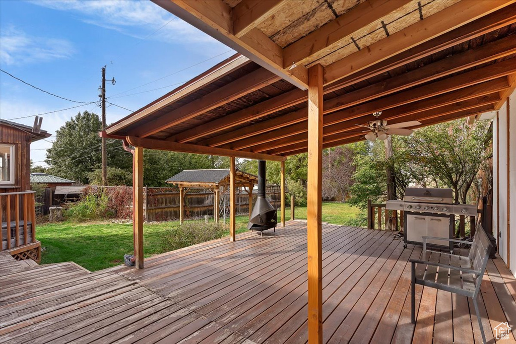 Wooden deck with a yard, grilling area, and ceiling fan